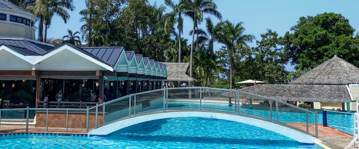 View of a walking bridge over a pool at an all-inclusive resort 