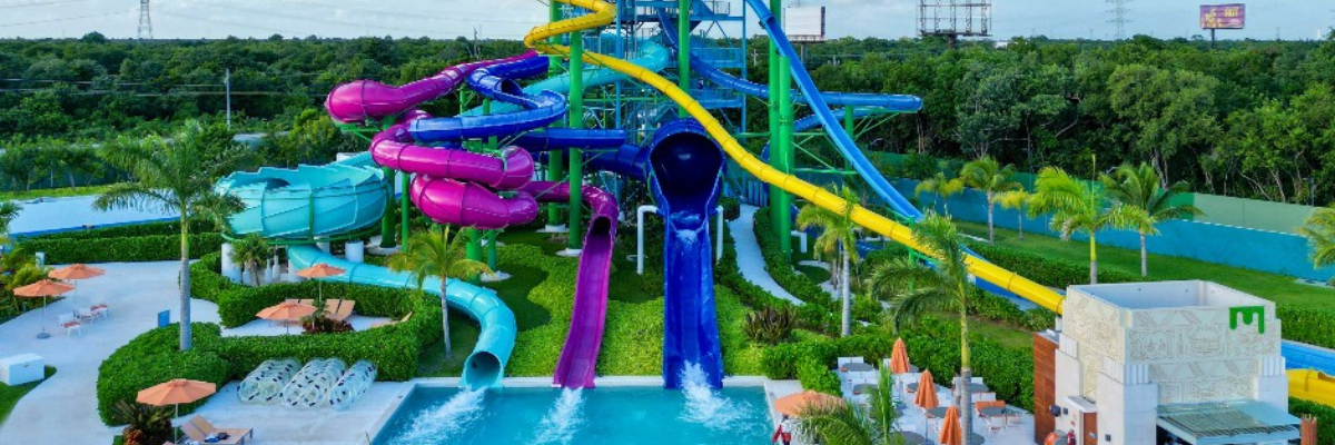 Waterpark in Mexico with a lot of colorful waterslides with green foliage in the background